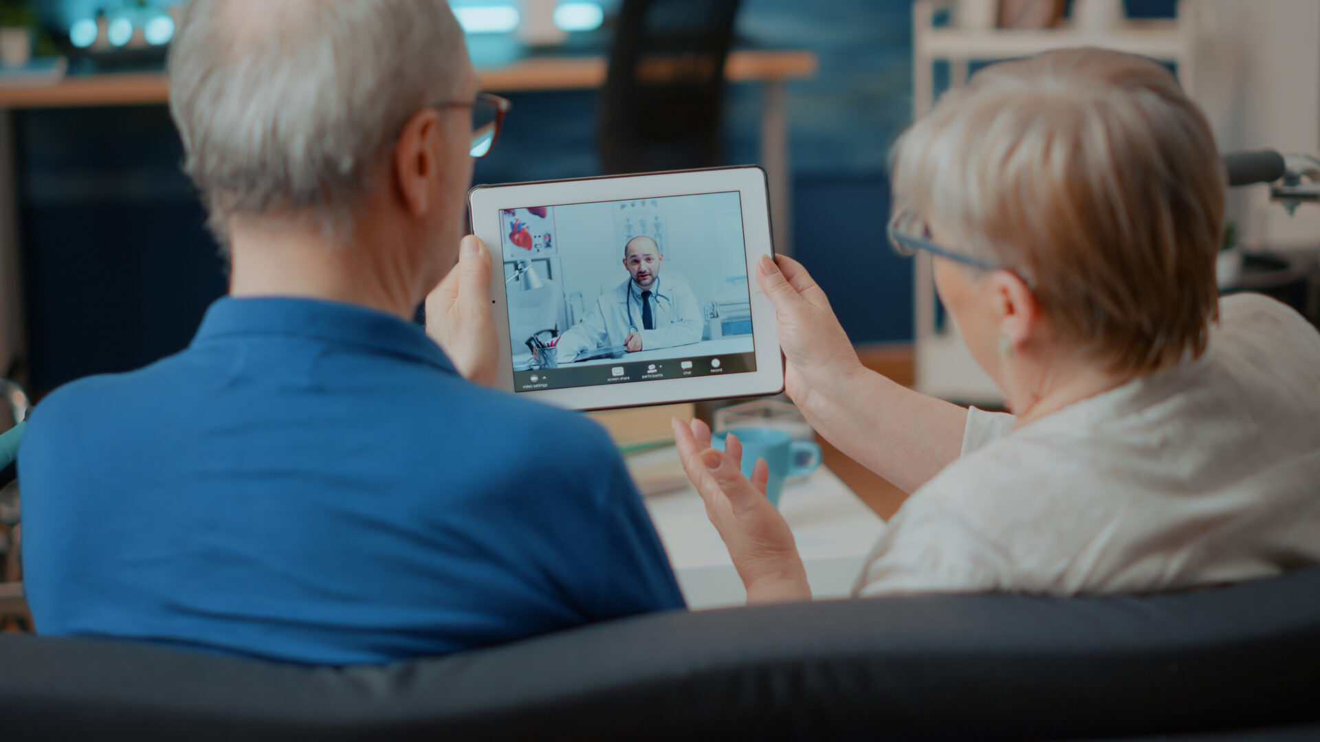Senior couple attending online meeting with doctor on digital tablet